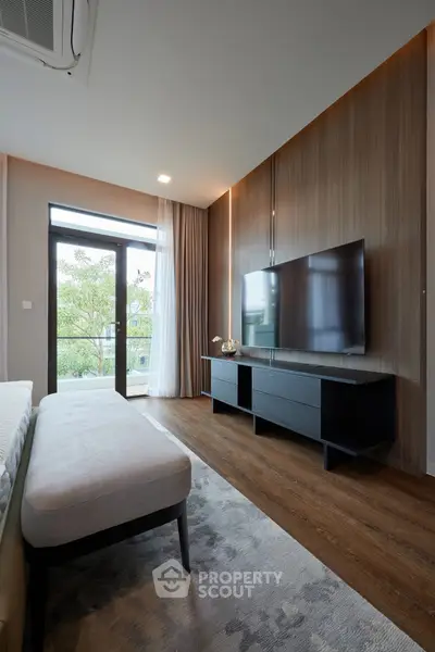 Modern living room with sleek TV setup and large window view.