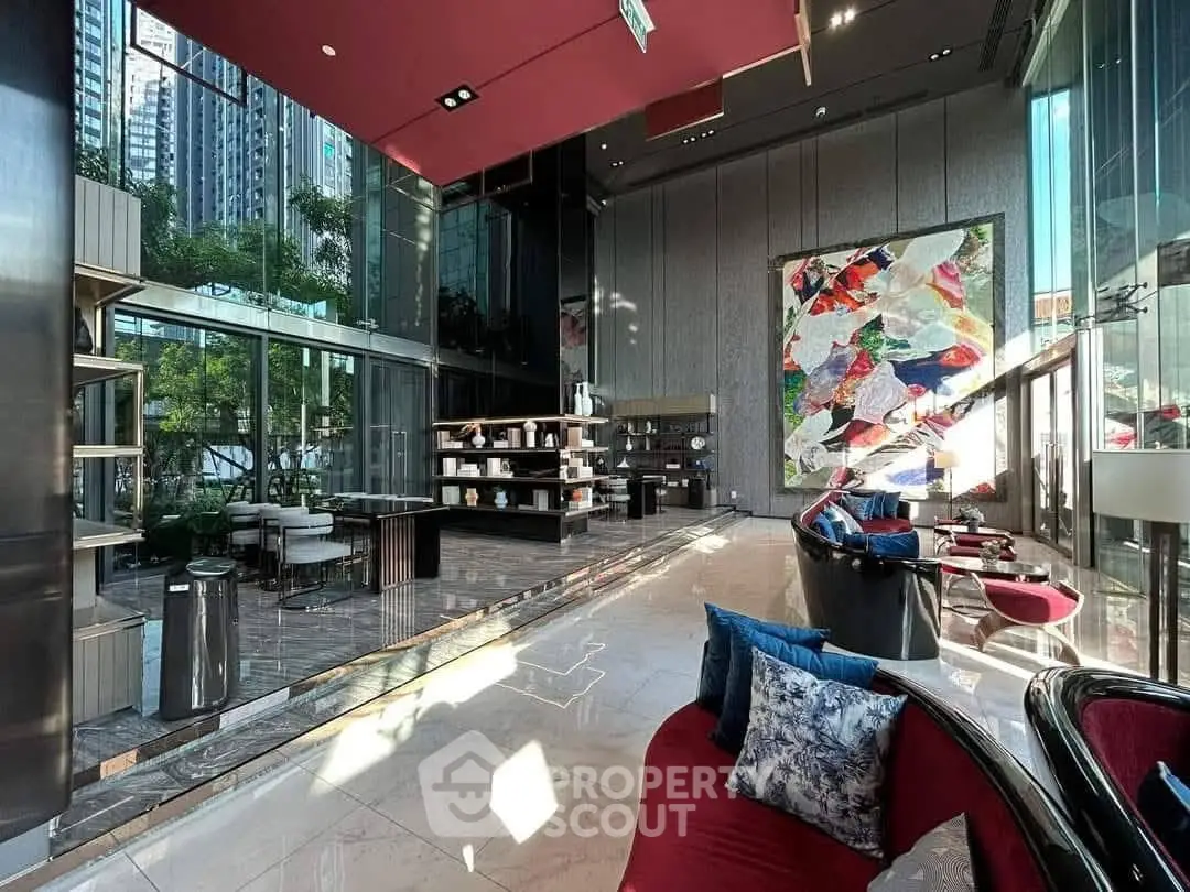 Luxurious modern lobby with high ceilings, elegant decor, and vibrant artwork in a prestigious building.