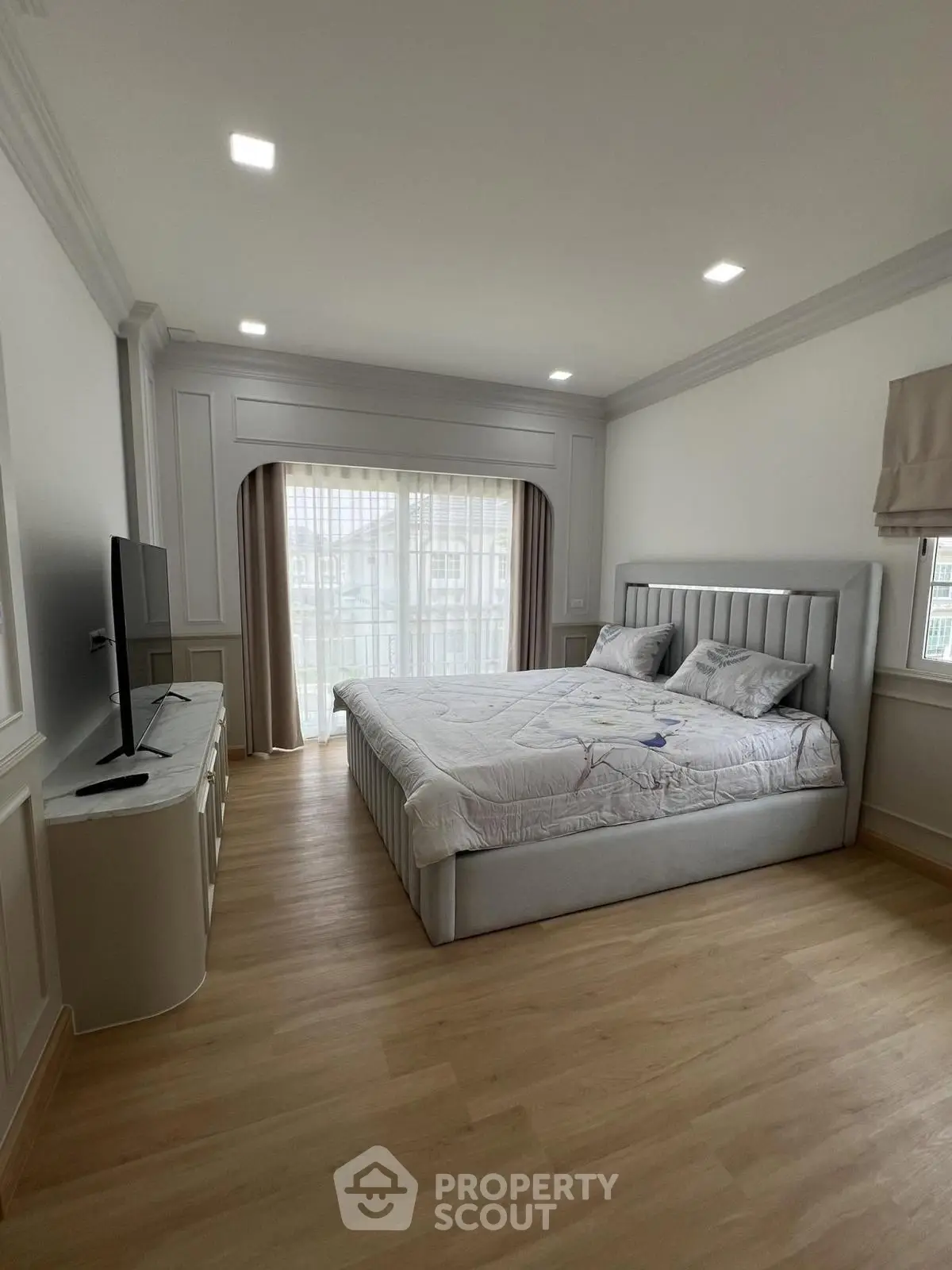 Spacious bedroom with elegant decor and large window for natural light