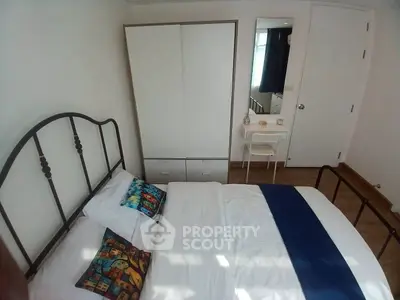 Cozy bedroom with modern decor and ample natural light, featuring a stylish bed and wardrobe.