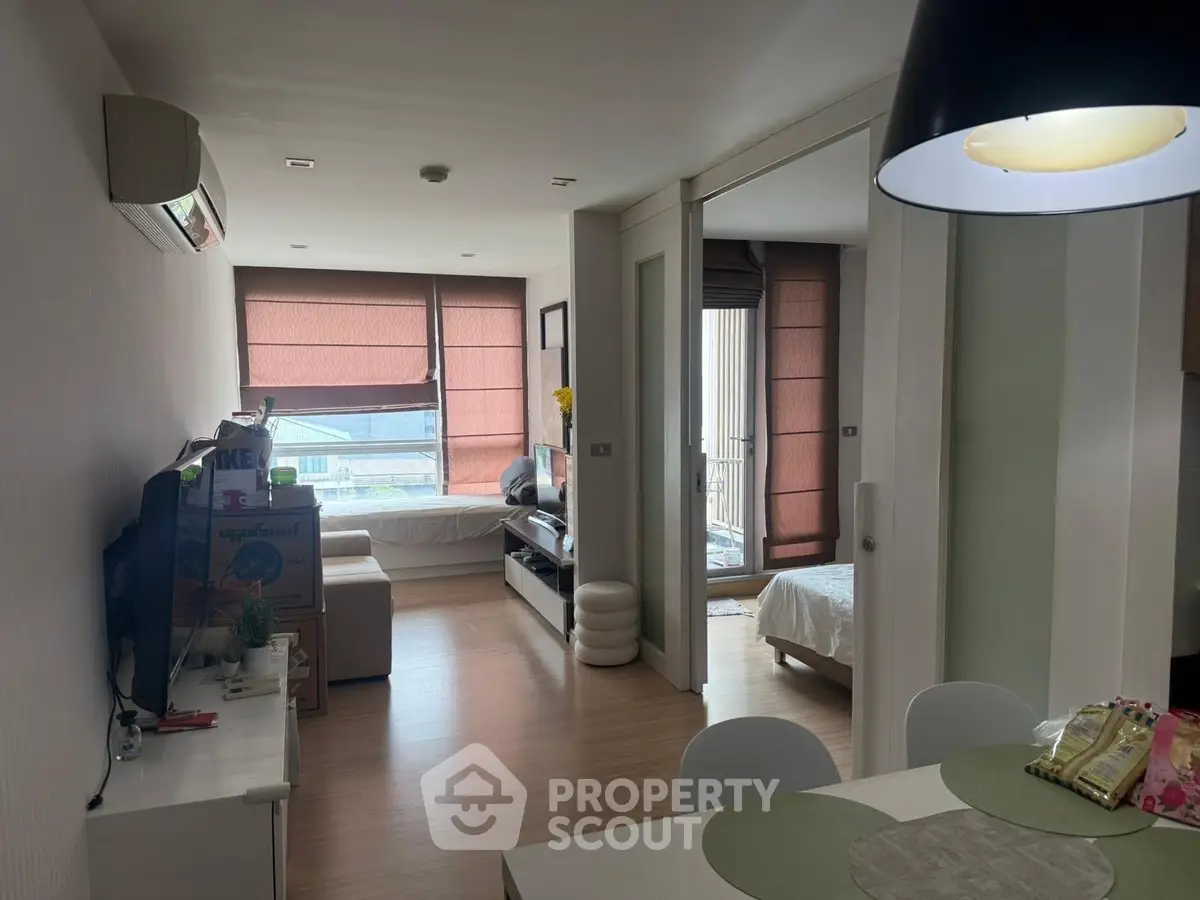 Modern apartment interior with open living and dining area, featuring natural light and stylish decor.