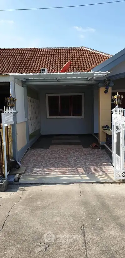 Charming single-story home with tiled driveway and gated entrance, perfect for cozy living.