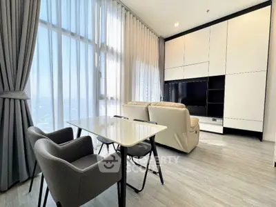 Modern living room with sleek furniture and large windows in a high-rise apartment