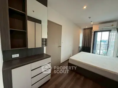 Modern bedroom with sleek furniture and city view balcony, perfect for urban living.