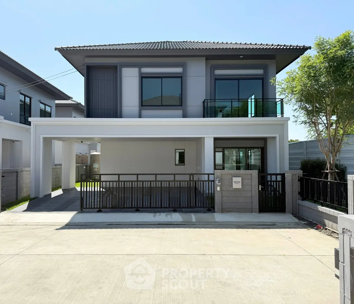 Modern two-story house with sleek design and spacious driveway in a serene neighborhood.