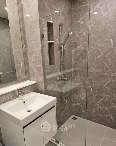 Modern bathroom with sleek glass shower and elegant marble tiles
