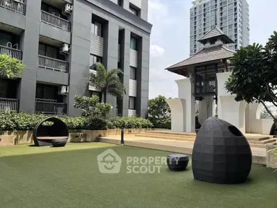 Modern apartment building with landscaped garden and unique outdoor seating area.