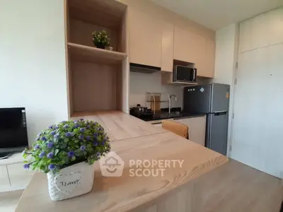 Modern kitchen with sleek cabinetry and stainless steel appliances in a cozy apartment.