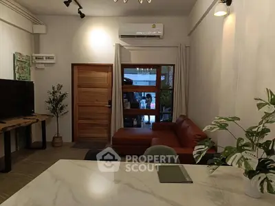 Modern living room with stylish furniture and air conditioning, featuring a cozy sofa and elegant decor.
