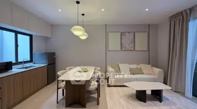 Modern living room with open kitchen, stylish dining area, and cozy seating in a contemporary apartment.