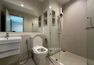 Modern bathroom with glass shower and sleek fixtures in a contemporary apartment.