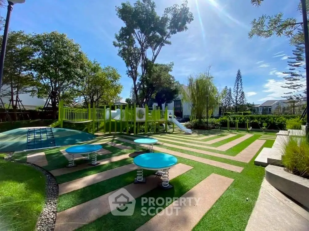 Beautifully landscaped playground with modern equipment in a serene residential community.