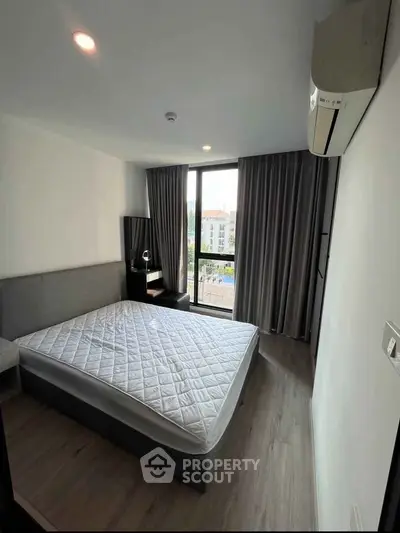 Modern bedroom with large window and air conditioning in a stylish apartment.