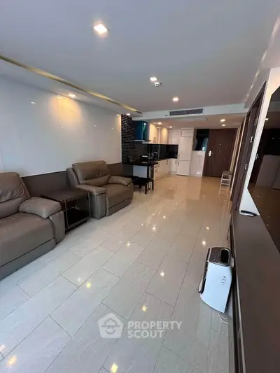 Spacious modern living room with open kitchen and sleek leather sofas