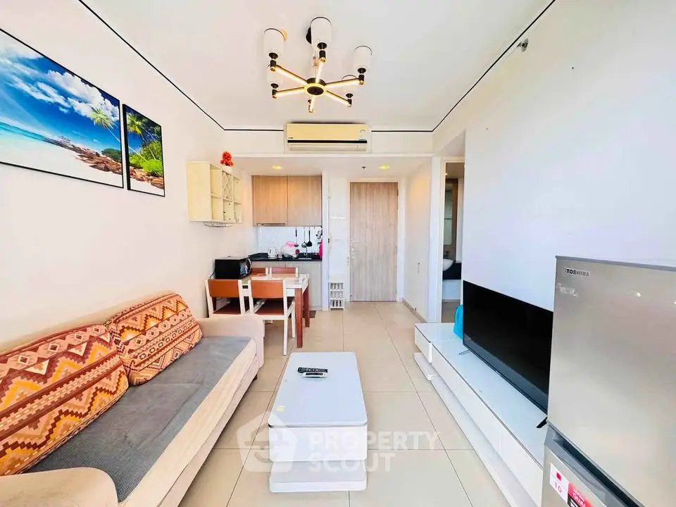 Modern living room with stylish decor and open kitchen layout, featuring a cozy sofa and sleek TV setup.