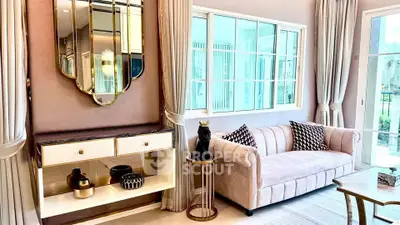 Elegant living room with plush sofa, stylish decor, and large windows for natural light.