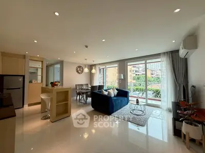 Spacious modern living room with open kitchen and balcony view