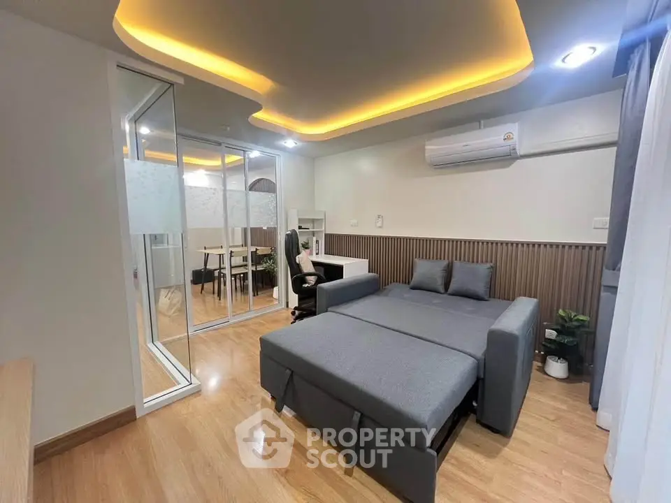 Modern living room with stylish lighting and convertible sofa bed in contemporary apartment.