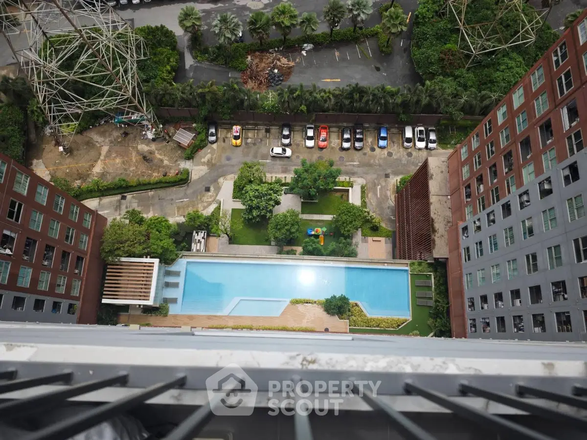 Stunning aerial view of modern apartment complex with pool and lush greenery, perfect for urban living.