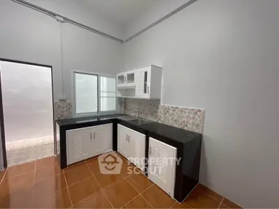 Modern kitchen with sleek black countertops and white cabinets in a cozy home setting.