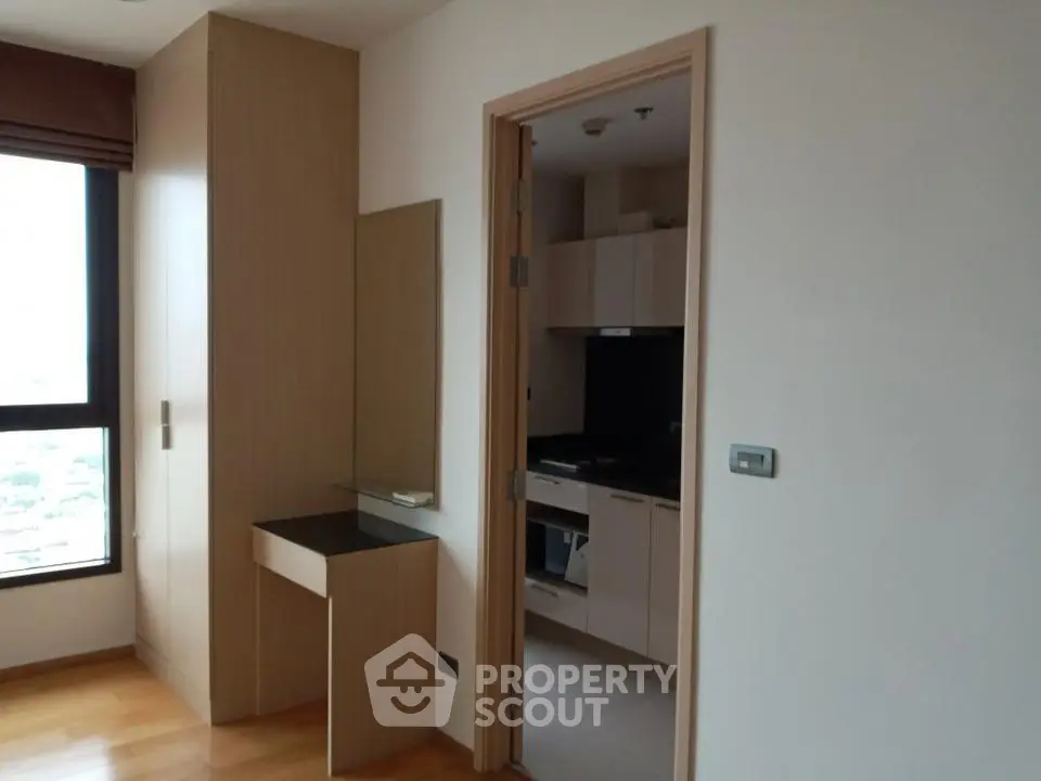 Modern apartment interior with wooden flooring and sleek kitchen design.