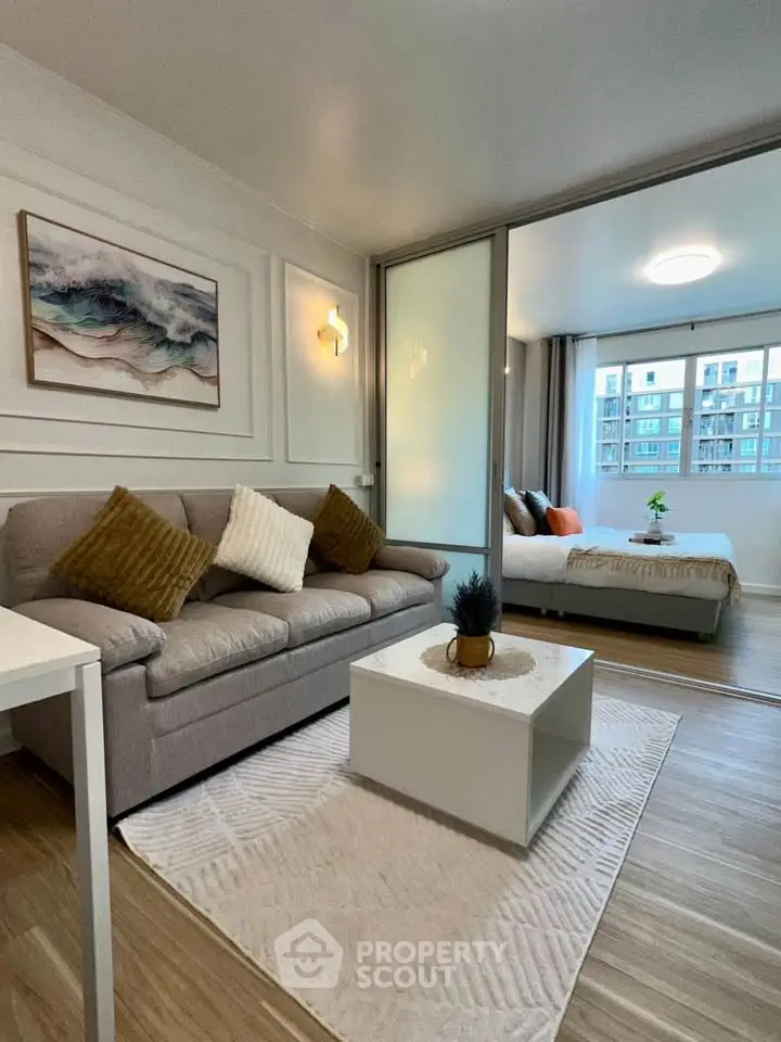 Modern living room with cozy sofa and stylish decor in open-plan apartment.