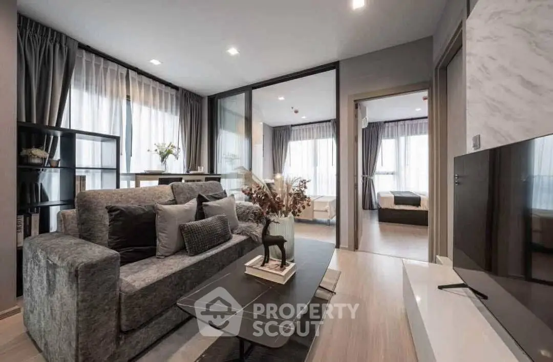 Modern living room with stylish decor and open layout leading to bedroom.