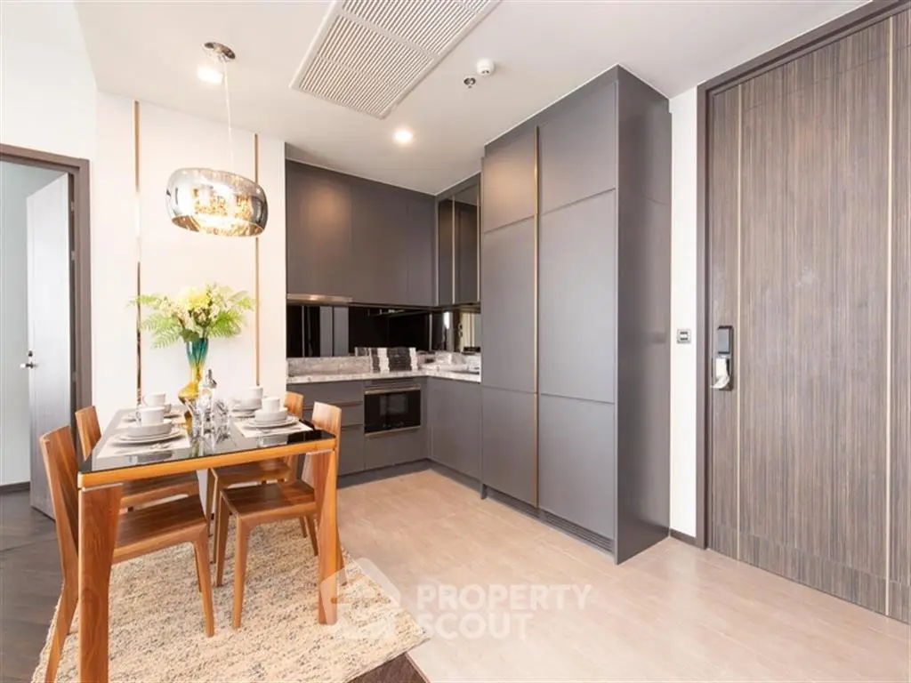 Modern kitchen with sleek cabinetry and dining area in contemporary apartment