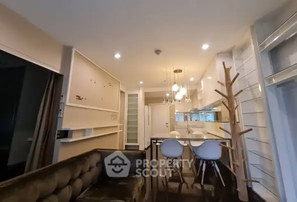 Modern open-plan living room with stylish kitchen and unique lighting fixtures.