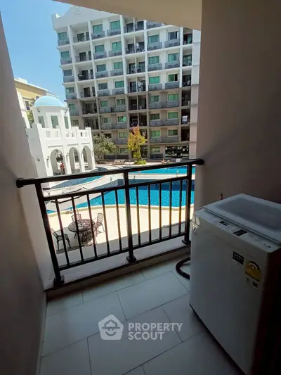 Charming balcony view overlooking a pool in a modern apartment complex.