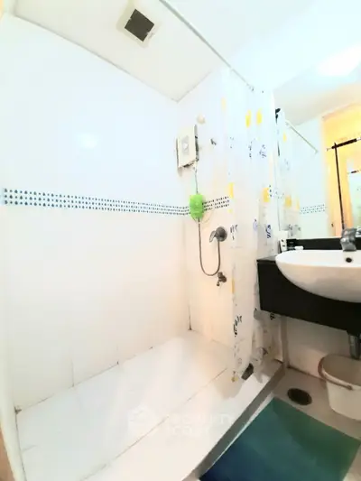 Compact bathroom with shower and sink in modern apartment