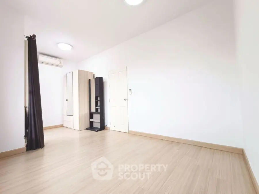 Spacious empty room with wooden flooring and wardrobe, ideal for customization.
