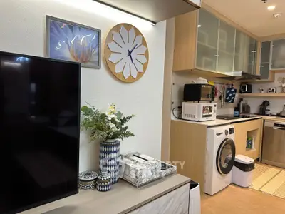 Modern kitchen with washing machine, microwave, and stylish decor in a cozy apartment setting.