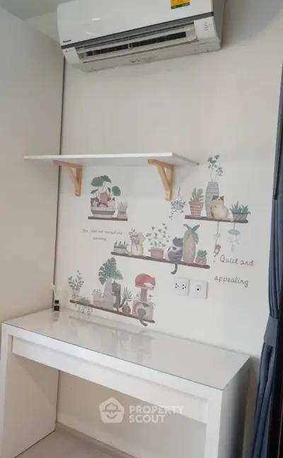 Charming study nook with wall art and air conditioning, perfect for a quiet workspace.