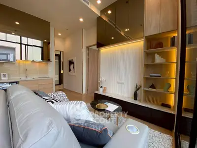 Modern living room with sleek design and open kitchen layout, featuring stylish decor and ample natural light.