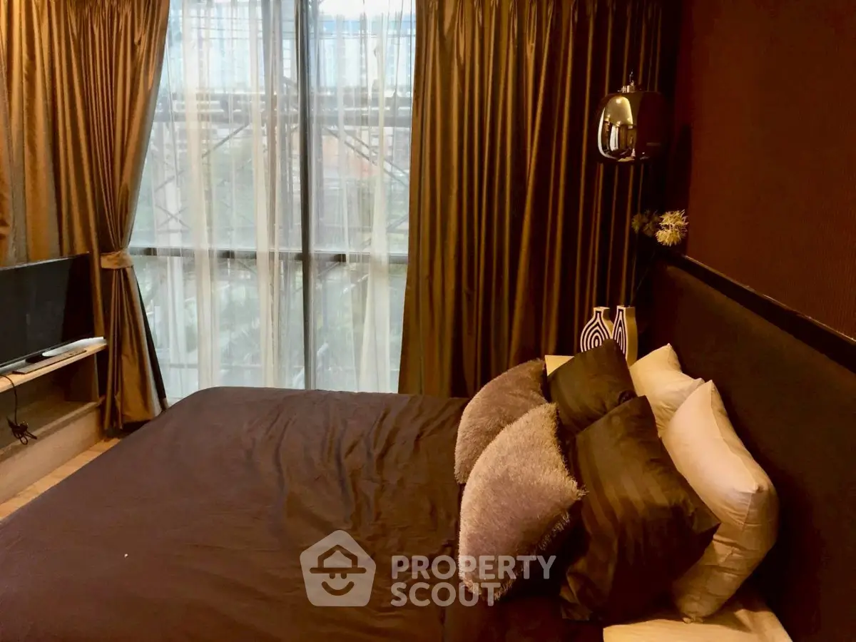 Luxurious bedroom with plush bedding and large window offering natural light