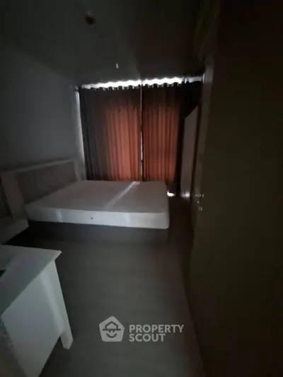 Cozy bedroom with large window and dark curtains, perfect for restful nights.