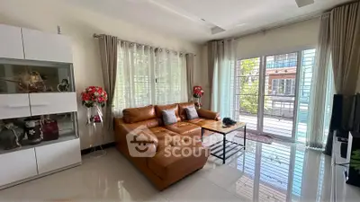 Spacious living room with modern leather sofa and large windows for natural light.