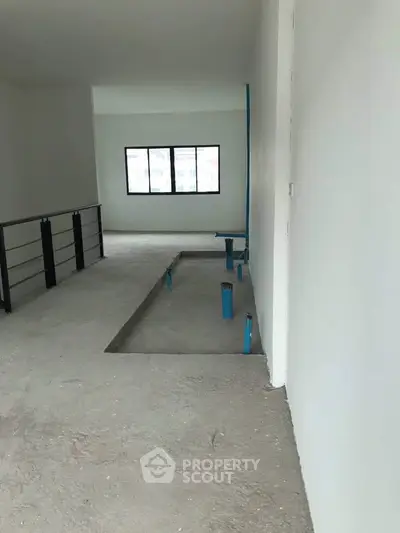 Spacious unfinished interior with large window and open layout, ideal for customization.