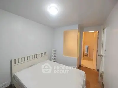 Cozy bedroom with minimalist design and soft lighting, perfect for relaxation.