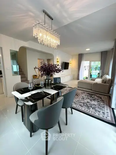 Elegant living and dining area with modern decor and chandelier lighting