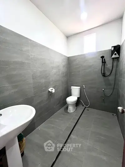 Modern minimalist bathroom with gray tiles and sleek fixtures