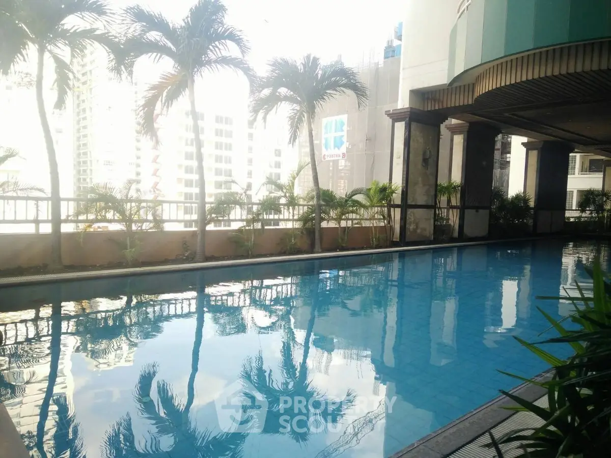 Luxurious rooftop pool with city skyline view and palm trees, perfect for relaxation and leisure.