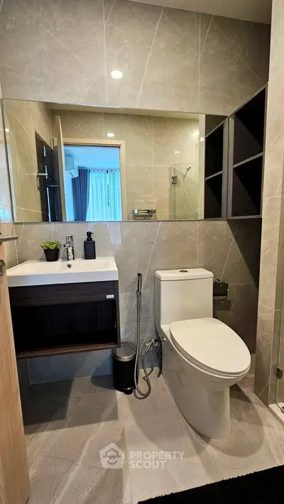 Modern bathroom with sleek fixtures and elegant tile design, featuring a stylish vanity and contemporary toilet.