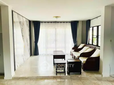 Spacious living room with elegant curtains and comfortable seating in a modern home.