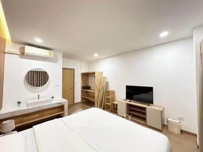 Modern bedroom with minimalist decor and built-in vanity in a stylish apartment.