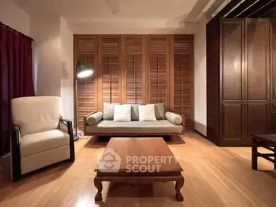 Cozy living room with wooden flooring, elegant furniture, and warm lighting.