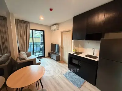 Modern living room with open kitchen and balcony access in stylish apartment.