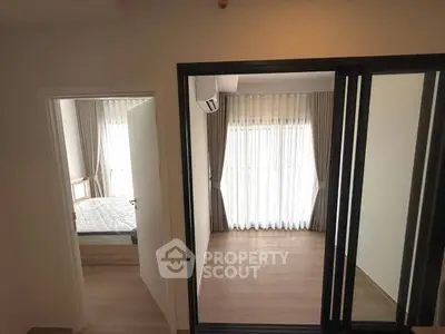 Spacious bedroom with large windows and elegant curtains in modern apartment