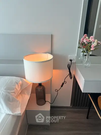 Modern bedroom with stylish lamp and elegant decor, perfect for cozy living.